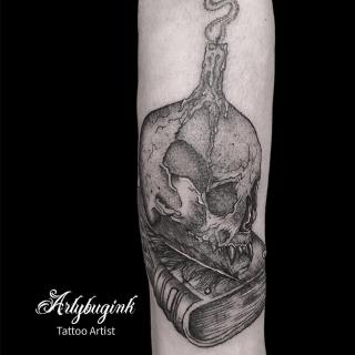 Skull on a book with candle tattoo by Artybugink